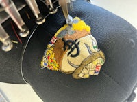 a hat is being sewn with a patch on it